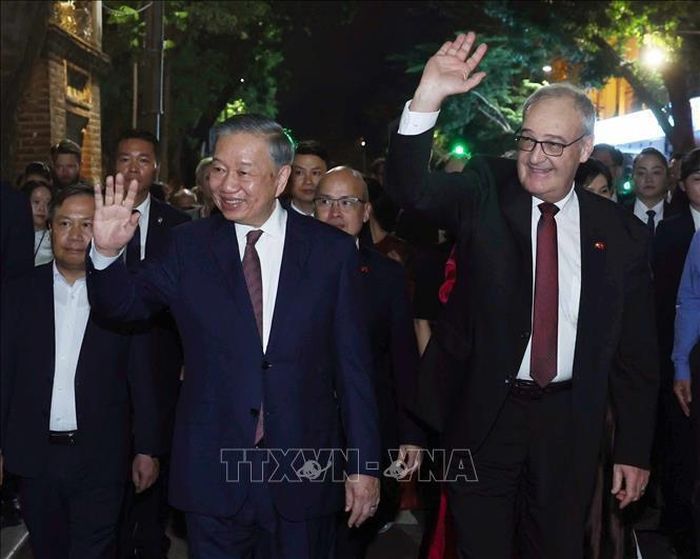 Tổng Bí thư, Chủ tịch nước Tô Lâm và Tổng thống Thụy Sĩ Guy Parmelin vẫy chào du khách và nhân dân Thủ đô khi dạo phố đi bộ hồ Hoàn Kiếm. Ảnh: Thống Nhất - TTXVN 