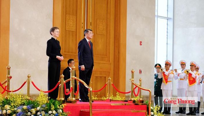 Thủ tướng Lê Minh Hưng và Thủ tướng Liechtenstein Brigitte Haas trên bục danh dự, nghe quân nhạc cử Quốc thiều hai nước.