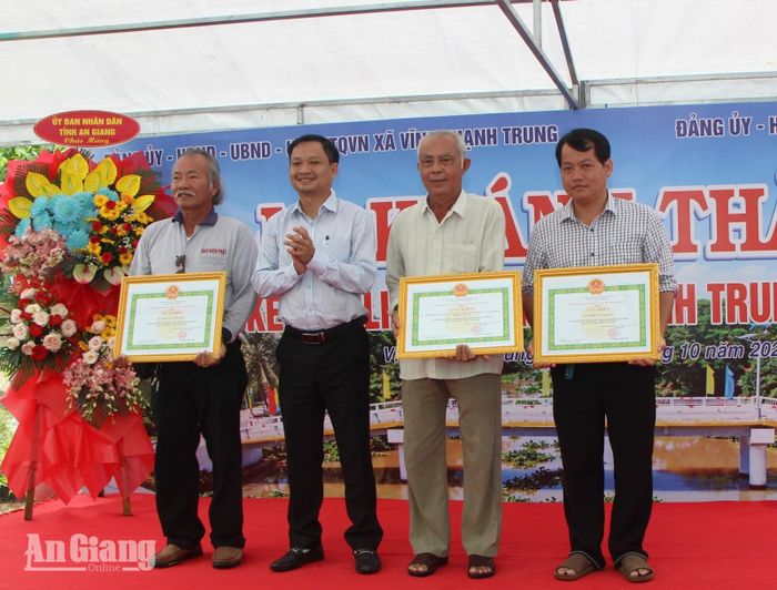 Phó Bí thư Đảng ủy, Chủ tịch UBND xã Vĩnh Thạnh Trung Lý Huỳnh Nhật Tiến tặng giấy khen của UBND xã cho các tập thể có thành tích đóng góp xây dựng cầu.