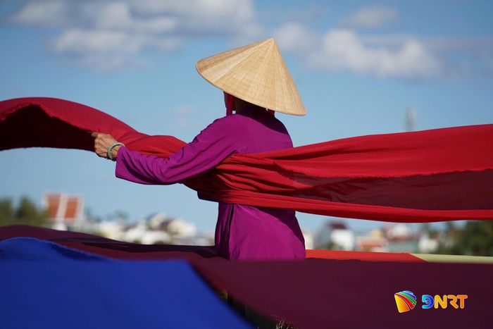 Giữa sắc màu của lụa, hình ảnh người phụ nữ hiện lên mềm mại, tạo nên khoảnh khắc giàu chất thơ trong lao động. Ảnh: KHA MIÊN