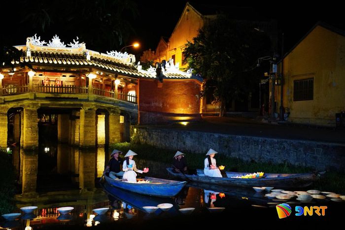 Nét đẹp dịu dàng của người phụ nữ hòa vào ánh đèn Hội An về đêm. Ảnh: KHA MIÊN