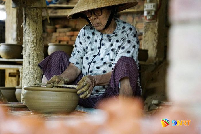 Bên bàn xoay gốm, sự khéo léo và bền bỉ làm nên nét đẹp riêng của người phụ nữ làng gốm Thanh Hà. Ảnh: KHA MIÊN