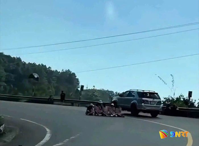 Nhóm du khách ngồi giữa đường để chụp ảnh ngay vị trí khúc cua. Hình ảnh cắt từ video clip trên mạng xã hội