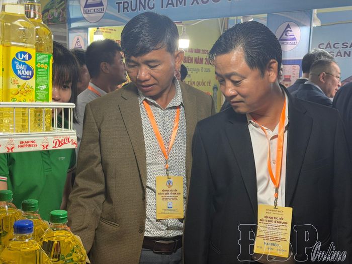 Ông Sôm Von Kẻo Khằm Phon, Chủ tịch Ủy ban Chính quyền huyện Phôn Thoong, tỉnh Luông Pha Băng, Lào (bên trái) tham quan các gian hàng tại hội chợ.
