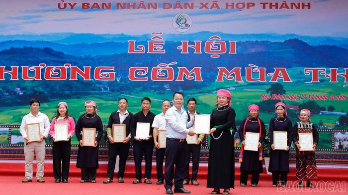 Ban Tổ chức trao giải Nhất cho đội thi thôn Hợp Thành trong phần thi giã cốm.