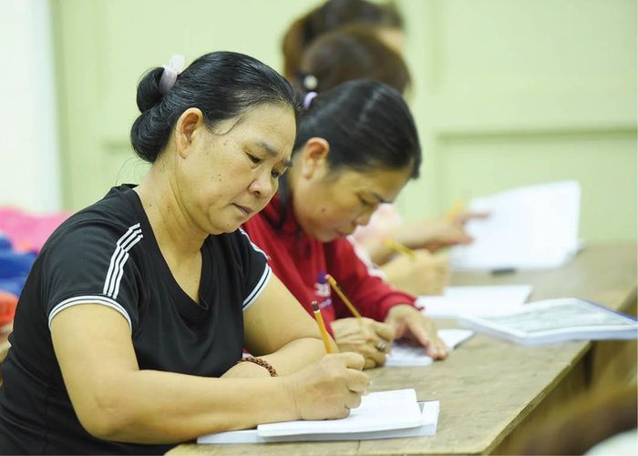Những người phụ nữ ngoài 60 tuổi vẫn miệt mài học chữ. 