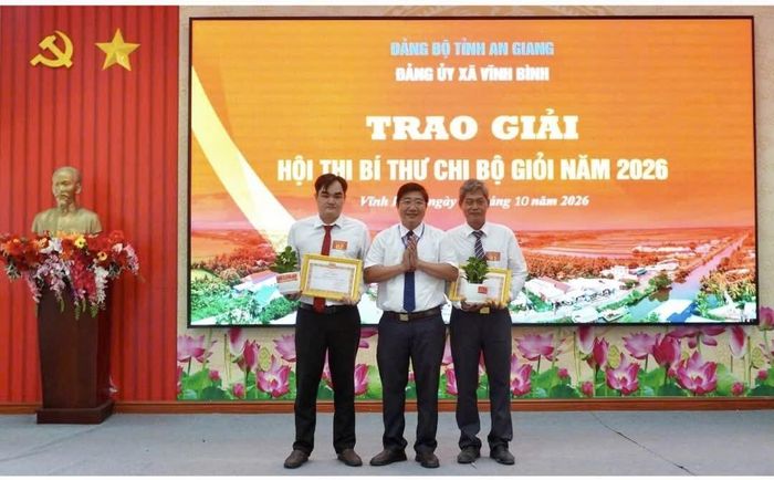 Đồng chí Võ Thanh Xuân, Phó Bí thư thường trực Đảng ủy xã Vĩnh Bình trao phần thưởng cho thí sinh đoạt giải Hội thi Bí thư Chi bộ giỏi năm 2026