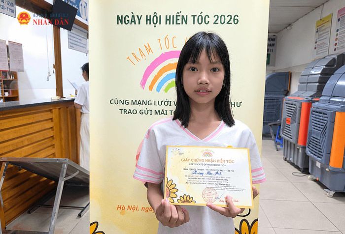 Em Bảo Anh (lớp 5A4, Trường Tiểu học Tiền Phong) vui mừng khi trao đi mái tóc nhỏ của mình cho các bạn bệnh nhi.