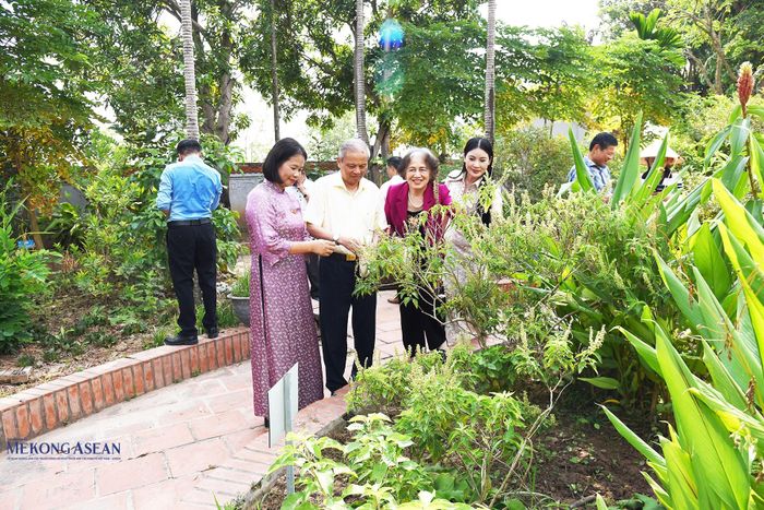 Các đại biểu thực hiện hái lá, cành thuốc tại vườn thuốc đền Bia. Ảnh: Phùng Nguyện.