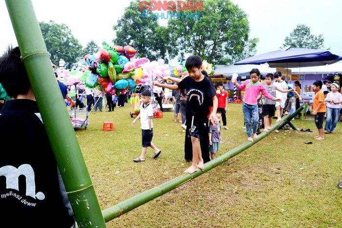 Trẻ em chơi trò đi cầu thăng bằng ở Lễ hội cốm mới. Ảnh: Quốc Hồng