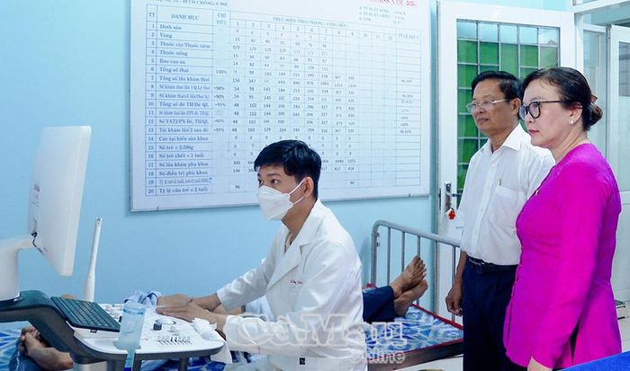 BS CKII Vương Hữu Tiến, Phó Giám đốc Sở Y tế tỉnh Cà Mau (người đứng, áo trắng) và PGS.TS.BS Nguyễn Minh Phương, Hiệu trưởng Trường Đại học Y Dược Cần Thơ (bìa phải), theo dõi quá trình siêu âm cho người dân.