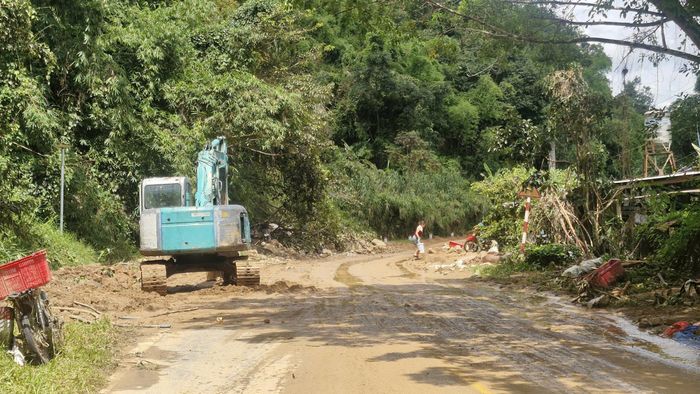 Máy móc, phương tiện vẫn đang dọn dẹp đất đá trên đường.