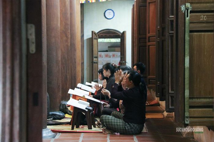 Phật tử thành kính tụng kinh trong không gian yên tĩnh của ngôi chùa cổ. Ảnh: Tuấn Anh