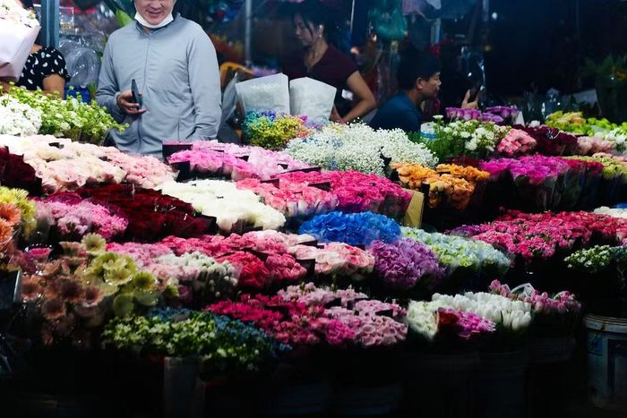 "Bữa tiệc" màu sắc mê hoặc tại chợ hoa, nơi hàng trăm bó hoa tươi thắm xếp thành từng lớp khoe sắc dưới ánh đèn đêm
