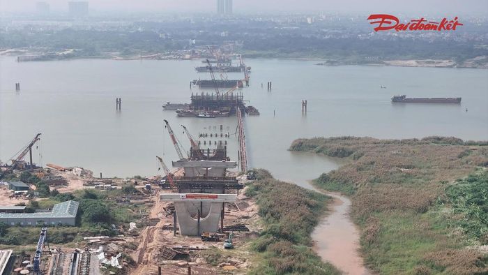 Theo ghi nhận tại công trường giữa tháng 10/2026, các kỹ sư, công nhân được bố trí thành nhiều mũi thi công, tập trung triển khai các hạng mục trụ cầu dưới lòng sông và trên bờ. Máy móc, sà lan hoạt động liên tục để phục vụ vận chuyển vật liệu, thi công cọc khoan nhồi, đổ bê tông trụ và đúc dầm.