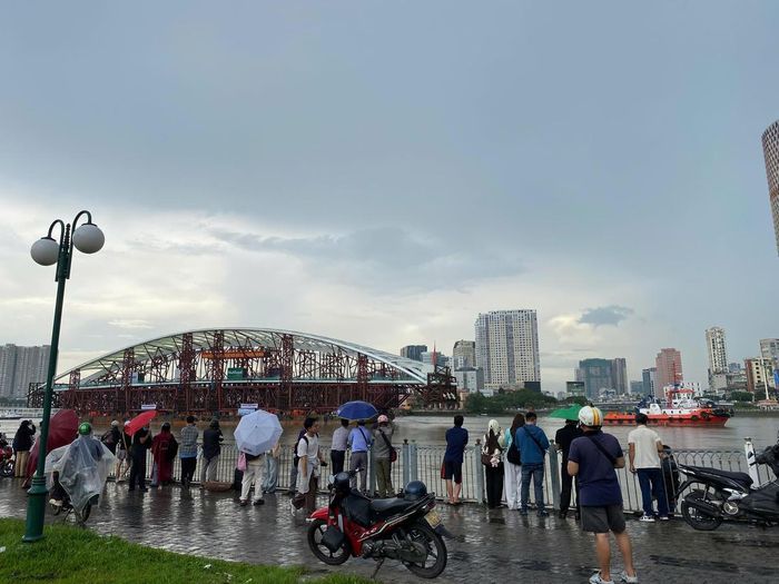 Người dân hiếu kỳ tìm tới bờ sông để tận mắt ngắm nhìn vòm thép. Ảnh: Đ.Xá.