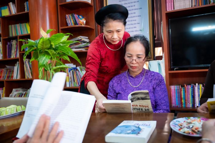  Từ ngày Thư viện làng cò Đông Xuyên ra đời, nhiều người dân mọi lứa tuổi vẫn thường xuyên tới đọc. Bà Đào Thị Khanh (bên trái) còn có một câu lạc bộ sinh hoạt văn nghệ, mở lớp dạy hát ca trù, nên trước mỗi buổi tập hát, bà lại cùng nhóm hát đọc sách 15 phút, như một cách để "khởi động" tinh thần. 