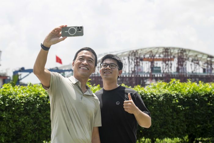 Ông Lê Hồng Minh, Nhà sáng lập kiêm Chủ tịch VNG, dùng điện thoại ghi lại đoàn tàu chở vòm cầu lá dừa lướt qua trước cổng công ty.
