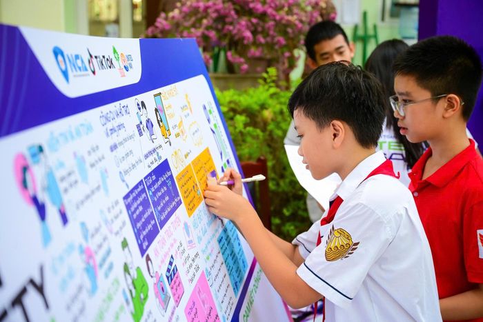  Học sinh viết cam kết đồng hành cùng chiến dịch Vaccine Số. Ảnh: BTC.