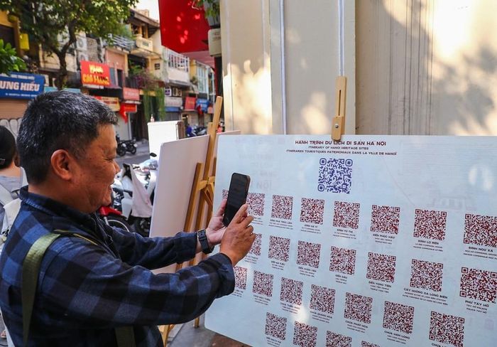 Người dân tìm hiểu thông tin các di tích qua nền tảng công nghệ số “Hành trình du lịch di sản Hà Nội”. Ảnh: Khánh Hòa