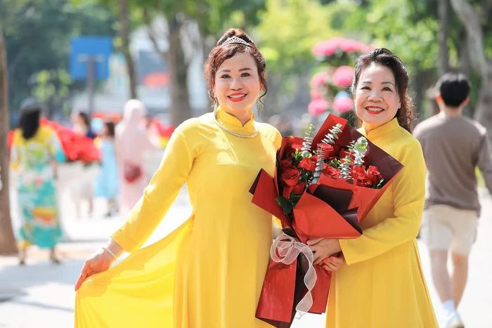 Phụ nữ cùng áo dài truyền thống tạo nên nét duyên dáng giữa không gian xanh mát bên hồ Hoàn Kiếm. Ảnh: Lê Đông - TTXVN