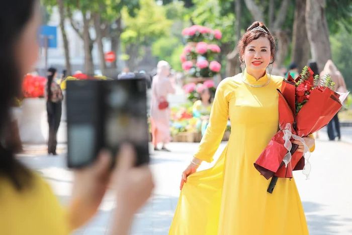 Người dân, du khách tranh ghi lại những kỷ niệm đẹp bên hồ Hoàn Kiếm nhân Ngày Phụ nữ Việt Nam 20/10. Ảnh: Lê Đông - TTXVN