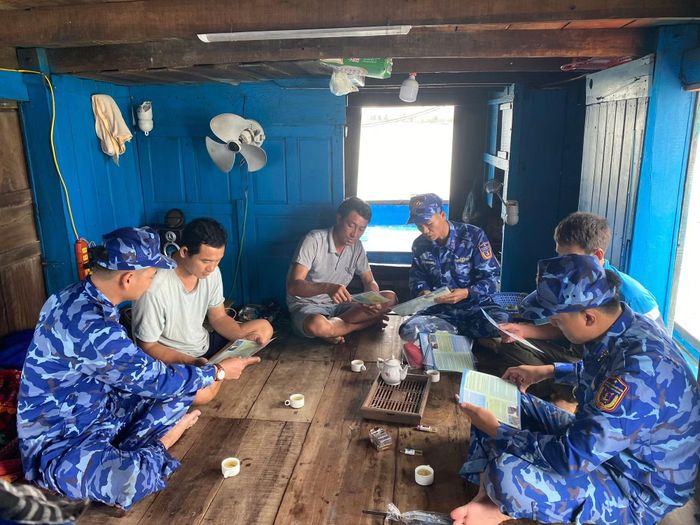 Cảnh sát viên tuyên truyền IUU cho bà con ngư dân. (Ảnh: NGUYỄN CHÍNH)