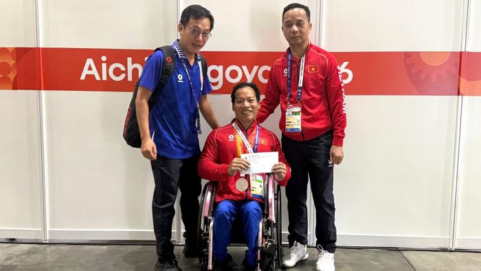 Phó Cục trưởng Thể dục thể thao,Trưởng Đoàn Thể thao người khuyết tật Việt Nam tại Asian Para Games 5 Nguyễn Trọng Hổ cùng Huấn luyện viên Lê Quang Thái chúc mừng Lê Văn Công. (Ảnh: HOÀI THU)