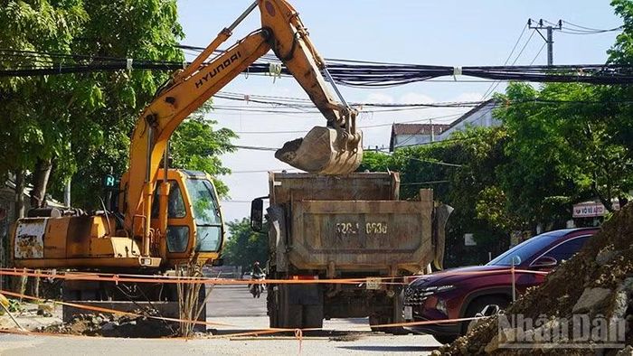 Phế thải nhựa đường, vật liệu xây dựng tại công trình Dự án Tuyến thoát nước ngầm đường Trưng Nữ Vương được múc lên xe sáng 19/10. (Ảnh: QUÂN VẠN)