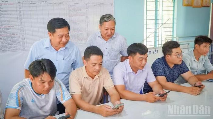 Phó Bí thư Thường trực Đảng ủy xã Tân Phước Hưng kiểm tra đảng viên đăng nhập hệ thống sổ tay đảng viên điện tử. (Ảnh:VĂN ÚT)