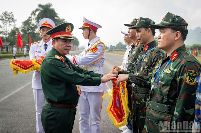 Trung tướng Nguyễn Bá Lực, Phó Tổng Tham mưu trưởng Quân đội nhân dân Việt Nam, Trưởng ban tổ chức Hội thao trao cờ lưu niệm tặng đại diện các đoàn tham dự. (Ảnh: THẾ ĐẠI)