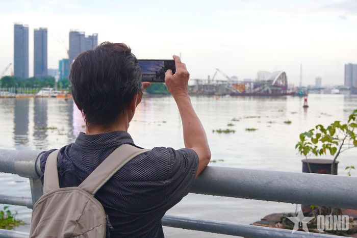 Người dân theo dõi, chào đón đoàn tàu lai dắt nhịp chính cầu đi bộ về trung tâm TP Hồ Chí Minh.