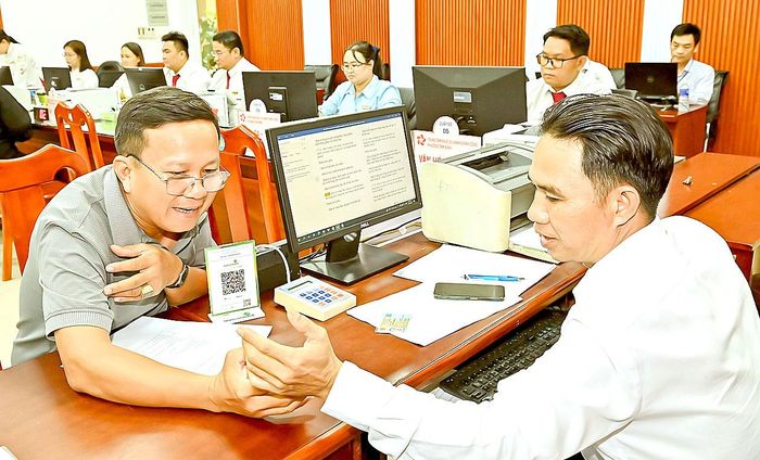  Cán bộ Trung tâm Phục vụ hành chính công phường Tam Bình (TPHCM) tiếp nhận, giải quyết hồ sơ cho người dân. Ảnh: VIỆT DŨNG 
