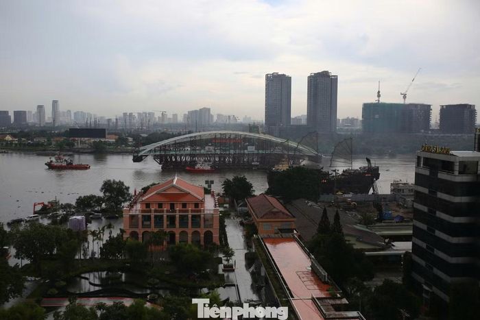 Lúc 14h45, sà lan chở vòm cầu thép tạo hình lá dừa nước dài 187 m đi qua Bến Nhà Rồng, hướng về công trường cầu đi bộ qua sông Sài Gòn.