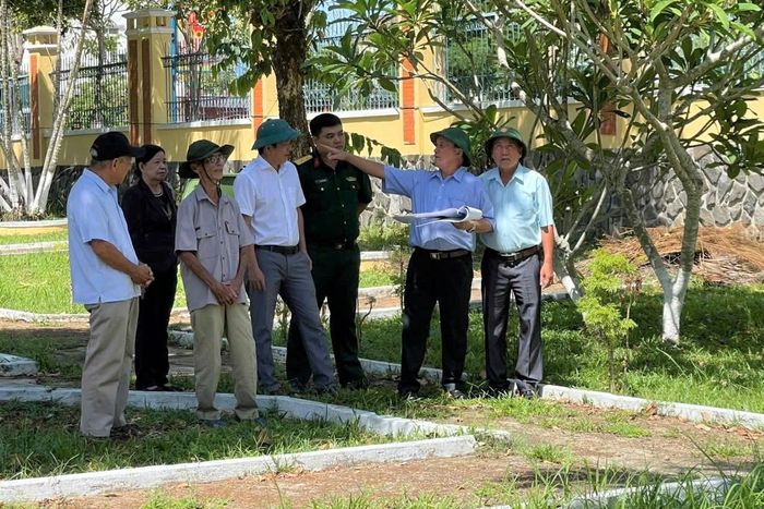 Chính quyền địa phương và các cựu chiến binh khảo sát khu vực nghi là nơi chôn cất liệt sĩ trong sân trụ sở Đảng ủy xã Hiệp Đức. Ảnh: H.Đ
