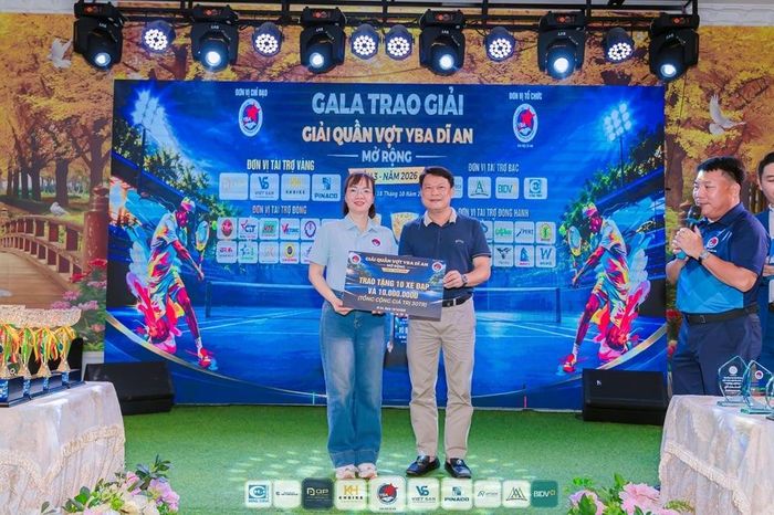Ông Nguyễn Thanh Huy - Chủ tịch UBND Phường Tân Đông Hiệp nhận bảng tượng trưng quà cho học sinh giỏi có hoàn cảnh khó khăn ở địa phương.