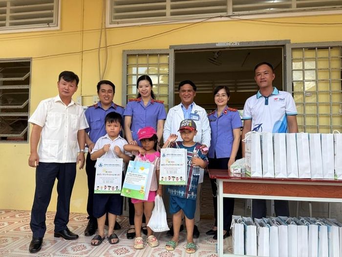 Thầy thuốc ưu tú, Bác sĩ chuyên khoa II Phan Ngọc Duy Cần trao quà cho các cháu sau khi khám bệnh.