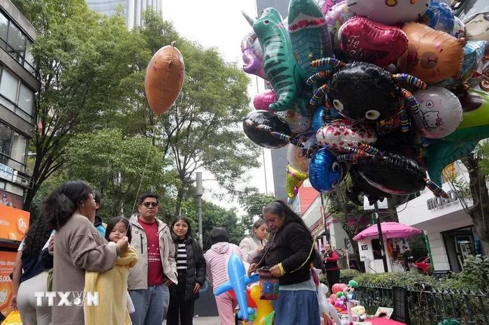 Một người bán bóng bay mang hình họa liên quan đến Día de Muertos. (Ảnh: Phi Hùng/TTXVN)