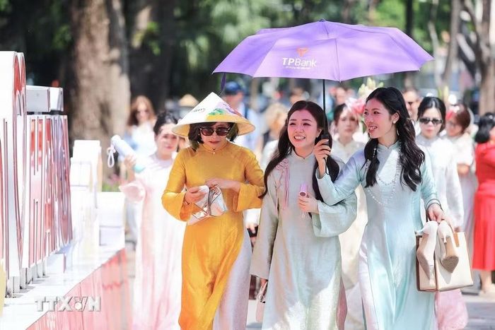 Người dân, du khách tranh thủ ghi lại những kỷ niệm đẹp bên hồ Hoàn Kiếm nhân Ngày Phụ nữ Việt Nam 20/10. (Ảnh: Lê Đông/TTXVN)