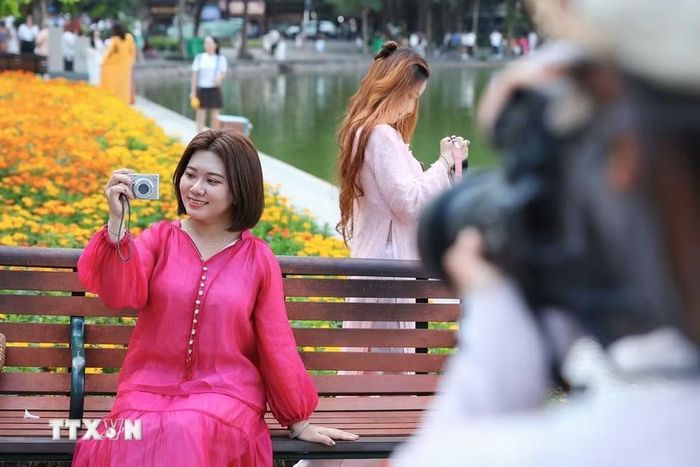 Giới trẻ thích thú vui chơi, chụp ảnh quanh khu vực hồ Hoàn Kiếm trong những ngày Hà Nội có thời tiết đẹp. (Ảnh: Lê Đông/TTXVN)