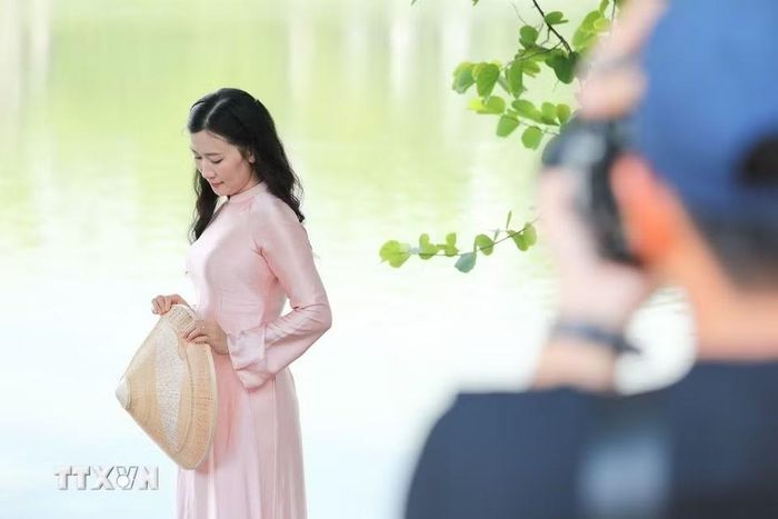 Tranh thủ thời tiết đẹp, ghi lại những khoảnh khắc bên hồ Hoàn Kiếm trong không khí hướng tới 20/10. (Ảnh: Lê Đông/TTXVN)