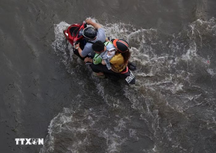 Các phương tiện lưu thông trên đường Trần Xuân Soạn, phường Tân Thuận, bị ngập do triều cường chiều 11/10. (Ảnh: Hồng Đạt/TTXVN)