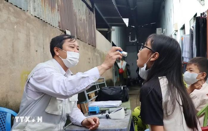Bác sỹ Trạm Y tế xã Hiệp Phước khám, kiểm tra sức khỏe cho học sinh khu vực ghi nhận ca bệnh não mô cầu. (Ảnh: Đinh Hằng/TTXVN)