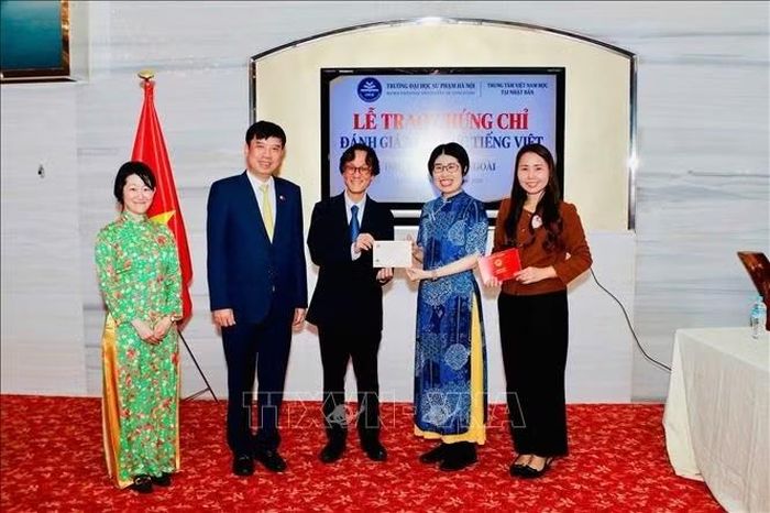 Giáo sư Shimizu Masaaki, Trưởng bộ môn tiếng Việt Đại học ngoại ngữ Osaka, trao chứng chỉ C1 tiếng Việt cho thí sinh Matsuoka Reina.