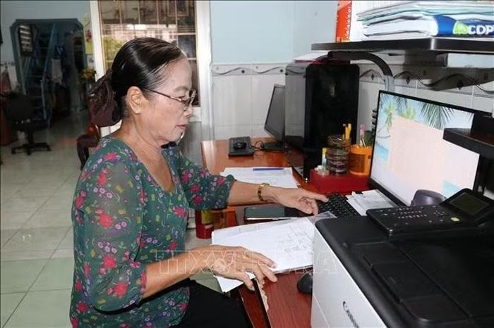 Bà Lâm Thị Cúc Huỳnh xử lý công việc trên máy vi tính, phục vụ các hoạt động thiện nguyện tại địa phương.