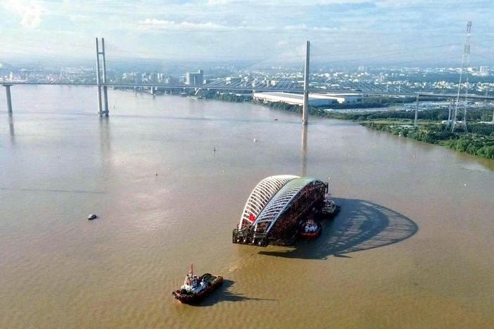 Đoàn phương tiện lai dắt kết cấu nhịp chính cầu đi bộ bắc qua sông Sài Gòn di chuyển qua cầu Bình Khánh, tiếp tục hành trình từ luồng Soài Rạp về bến Bạch Đằng, khu vực trung tâm TP Hồ Chí Minh.