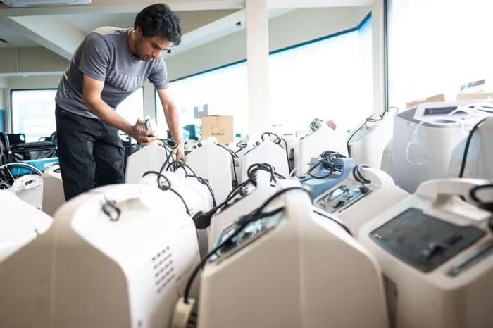 Một kỹ thuật viên kiểm tra các máy tạo oxy đang chờ sửa chữa và vệ sinh tại một kho hàng ở Kuala Lumpur. Ảnh: AFP.