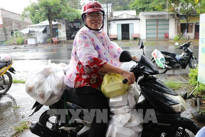 Cô Lâm Thị Cúc Huỳnh chuẩn bị giao các suất cơm đến tận nhà những người có hoàn cảnh khó khăn, không thể đến nhận trực tiếp. Ảnh: Thanh Hòa - TTXVN