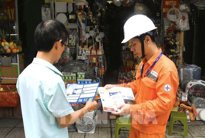 Cán bộ điện lực tuyên truyền cho người dân về những nguy cơ cháy nổ. Ảnh: Quốc Lũy - TTXVN 