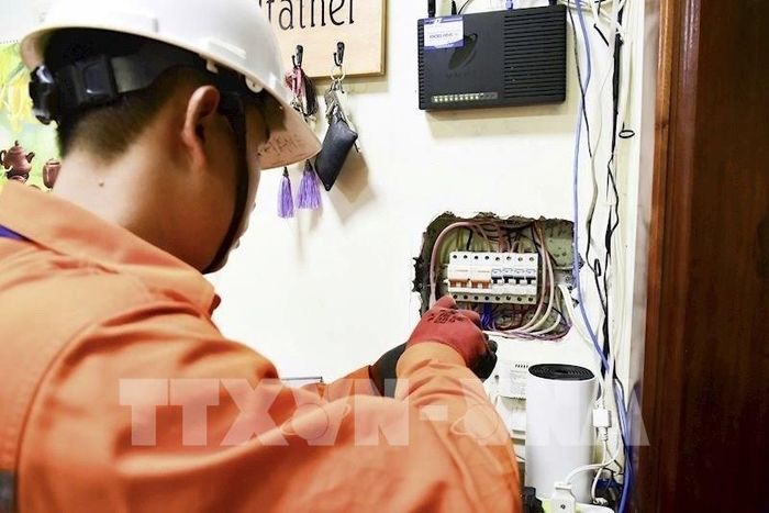 Công nhân EVNHANOI kiểm tra hệ thống điện tại hộ gia đình. Ảnh: Quốc Lũy - TTXVN 
